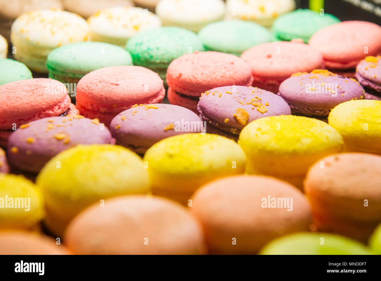 Assortimento di macaron colorati in vendita in negozio. Righe di amaretti in negozio di dolciumi, storefront con dolci, cafe vetrina. Tradizionale Francese ca di mandorla Foto Stock