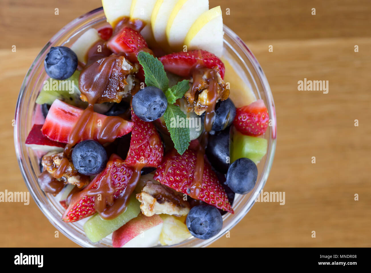 Ciotola con insalata di frutta e Topping Caramel - vista superiore Foto Stock
