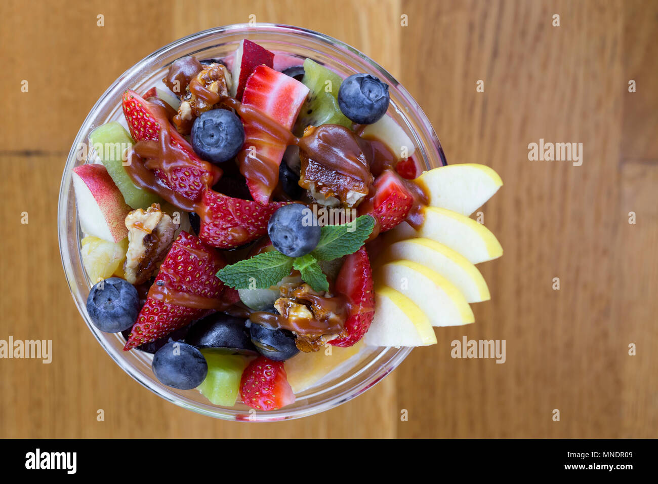 Ciotola con insalata di frutta e Topping Caramel - vista superiore Foto Stock