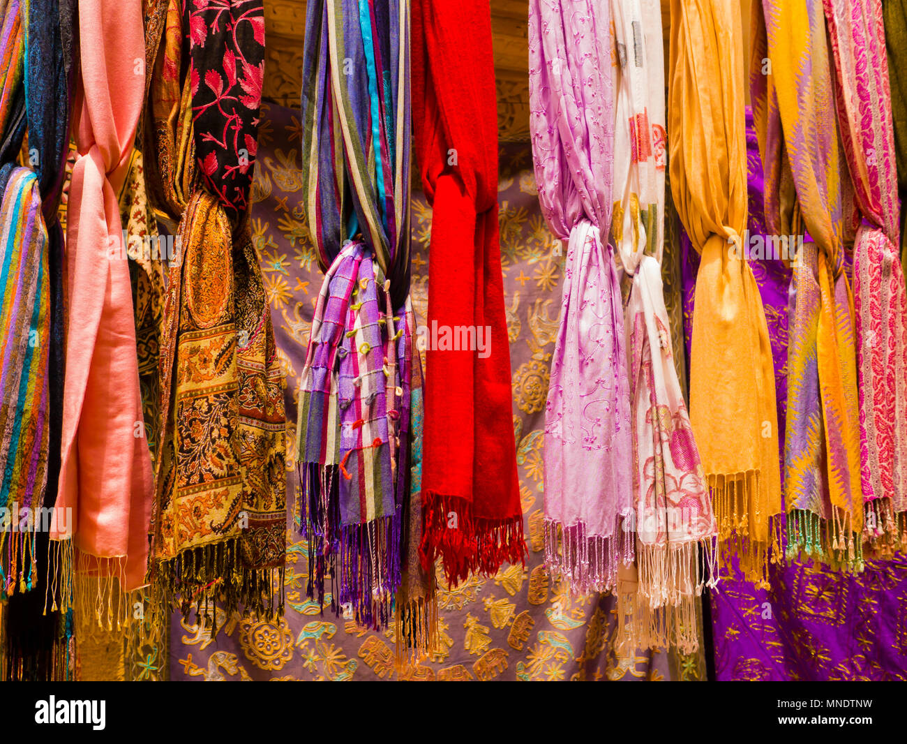 Fila di seta colorata scarvers appeso sul mercato in stallo, India Foto Stock