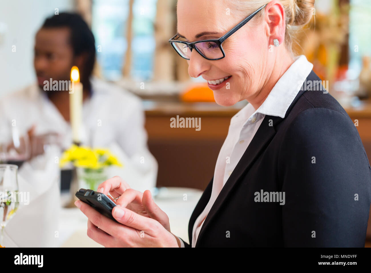 Donna sul business lunch controllo mail sul telefono Foto Stock