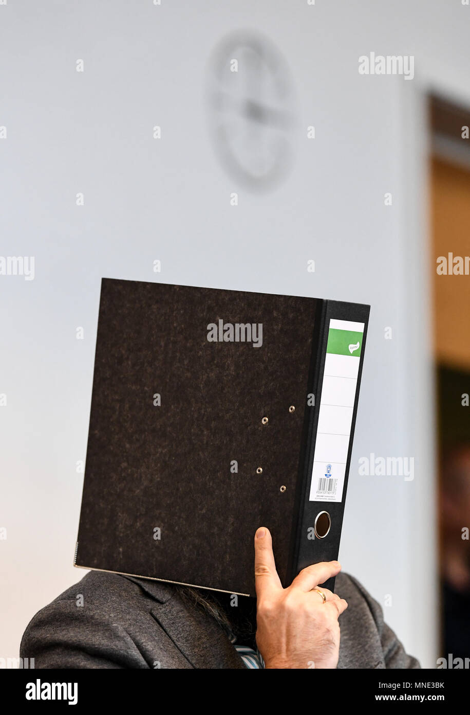 16 maggio 2018, Germania, Friburgo: Knut S., accusati di abusi sui minori, seduti in una sala del tribunale distrettuale e tenendo una cartella nella parte anteriore del suo volto. Un verdetto verrà passata per il caso di oggi. Il soldato da forze armate tedesche, che hanno trasformato il cinquanta oggi, è accusato di aver violentato un ragazzo due volte l'anno scorso nella città di Staufen vicino a Friburgo. Egli è stato anche accusato di filmatura della legge e di inviarlo ad altri. Foto: Patrick Seeger/dpa Foto Stock