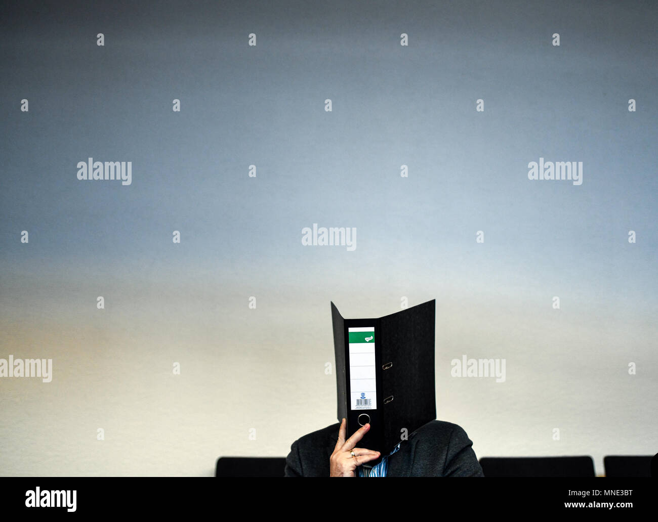 16 maggio 2018, Germania, Friburgo: Knut S., accusati di abusi sui minori, seduti in una sala del tribunale distrettuale e tenendo una cartella nella parte anteriore del suo volto. Un verdetto verrà passata per il caso di oggi. Il soldato da forze armate tedesche, che hanno trasformato il cinquanta oggi, è accusato di aver violentato un ragazzo due volte l'anno scorso nella città di Staufen vicino a Friburgo. Egli è stato anche accusato di filmatura della legge e di inviarlo ad altri. Foto: Patrick Seeger/dpa Foto Stock