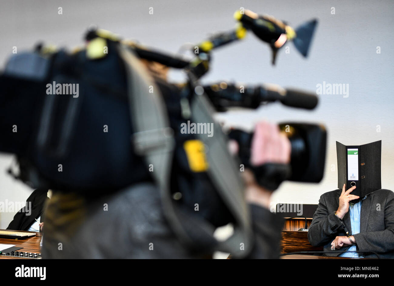 16 maggio 2018, Germania, Friburgo: Knut S., accusati di abusi sui minori, seduti in una sala del tribunale distrettuale e tenendo una cartella nella parte anteriore del suo volto. Un verdetto verrà passata per il caso di oggi. Il soldato da forze armate tedesche, che hanno trasformato il cinquanta oggi, è accusato di aver violentato un ragazzo due volte l'anno scorso nella città di Staufen vicino a Friburgo. Egli è stato anche accusato di filmatura della legge e di inviarlo ad altri. Foto: Patrick Seeger/dpa Foto Stock