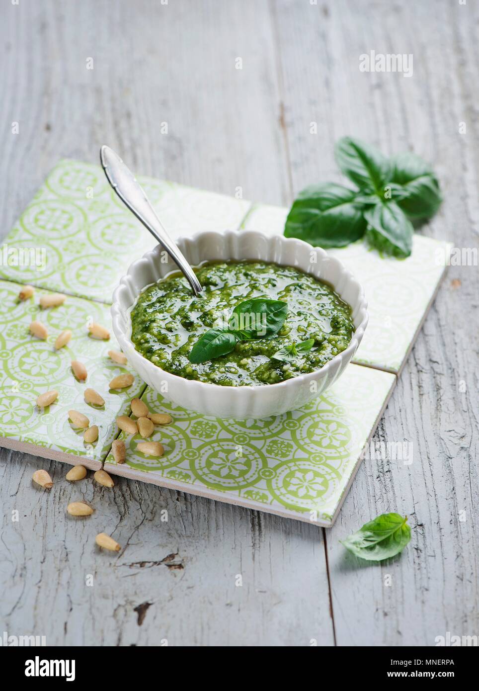 Il Pesto in una ciotola bianco; si estendesse il lato; cucchiaio Foto Stock