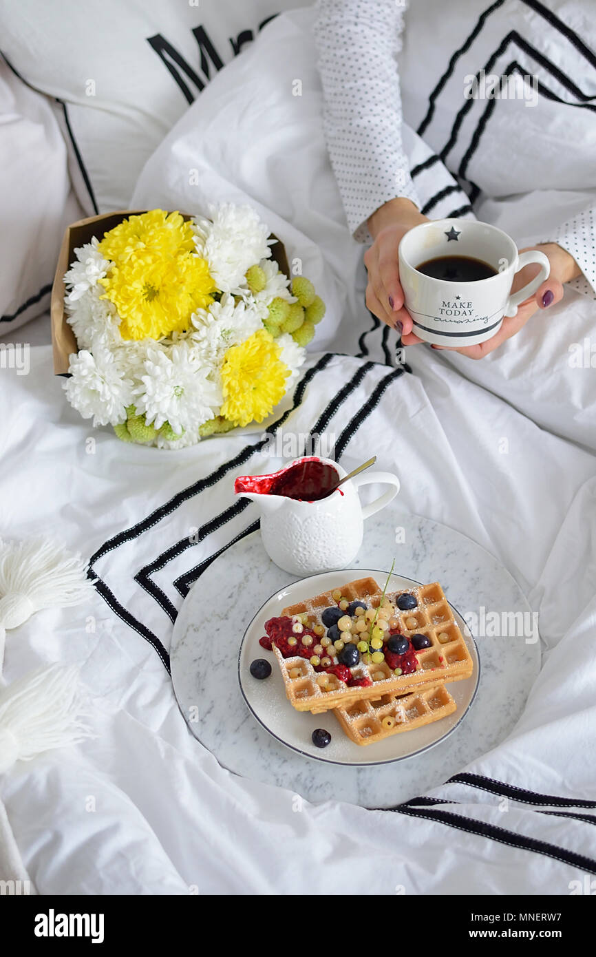 La prima colazione a letto con caffè e cialde con frutti di bosco freschi Foto Stock