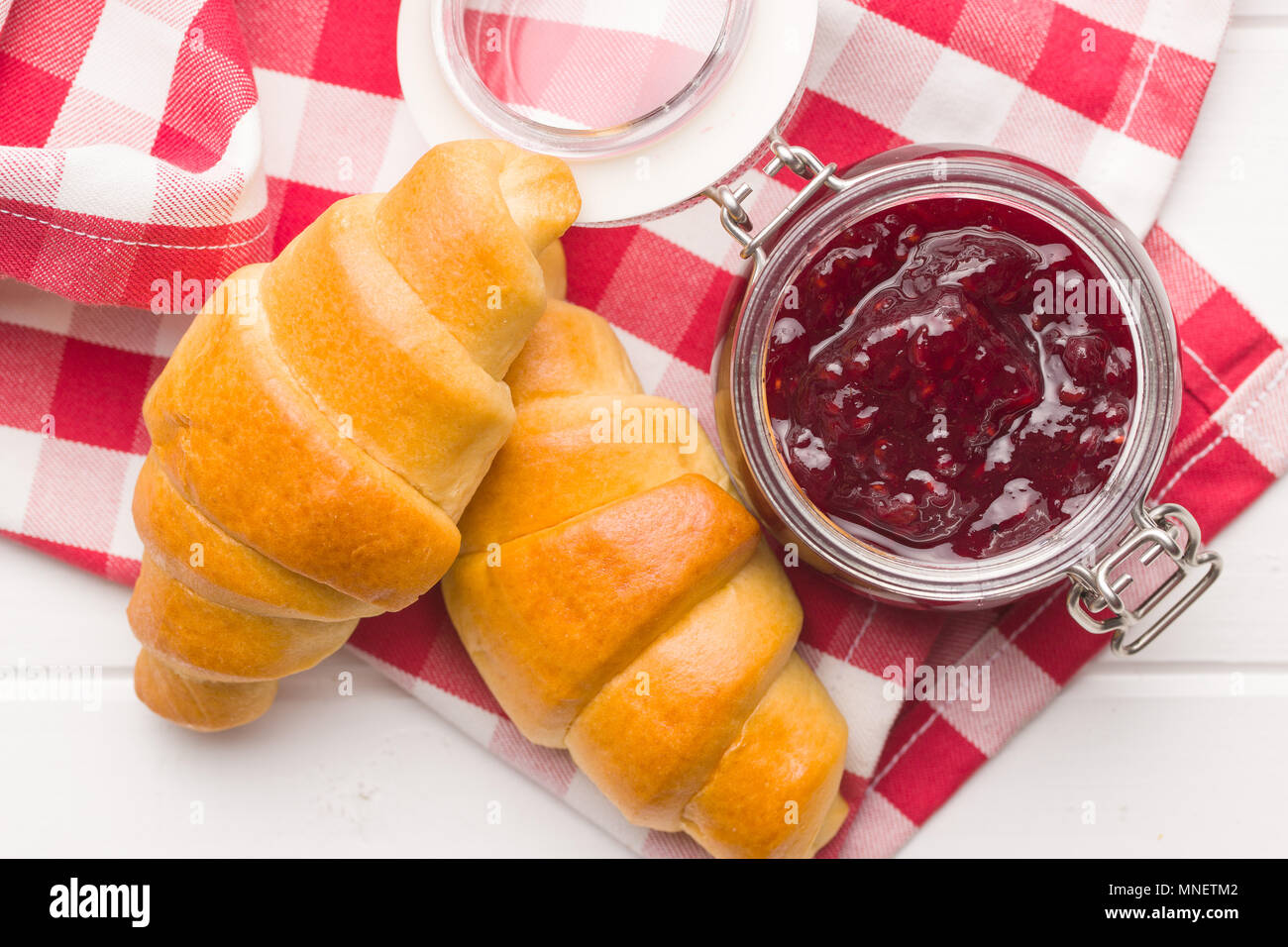 Cornetti dolci e marmellate sul tovagliolo a scacchi. Foto Stock