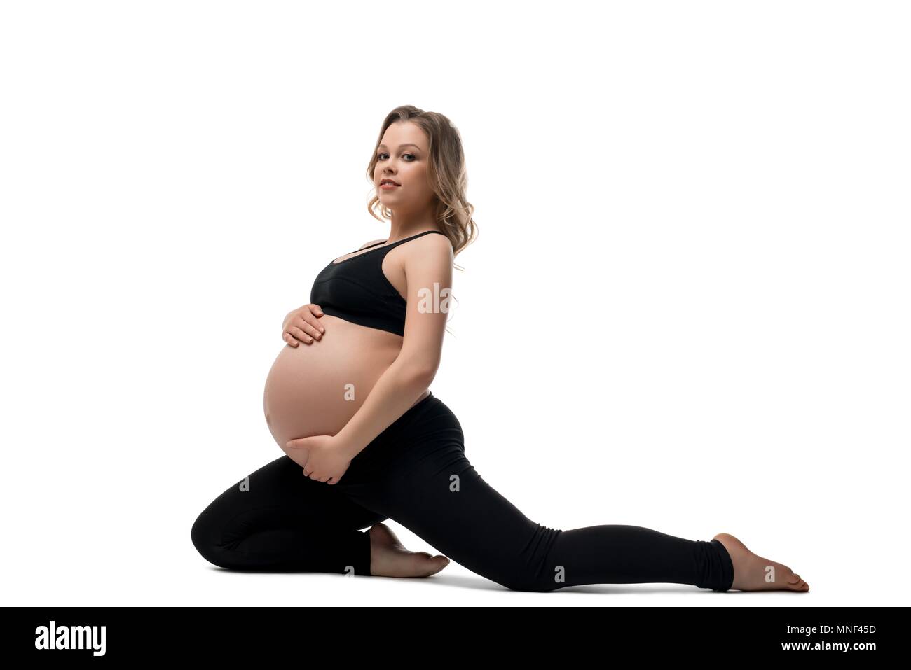 Bionda incinta facendo esercizio isolato shot Foto Stock