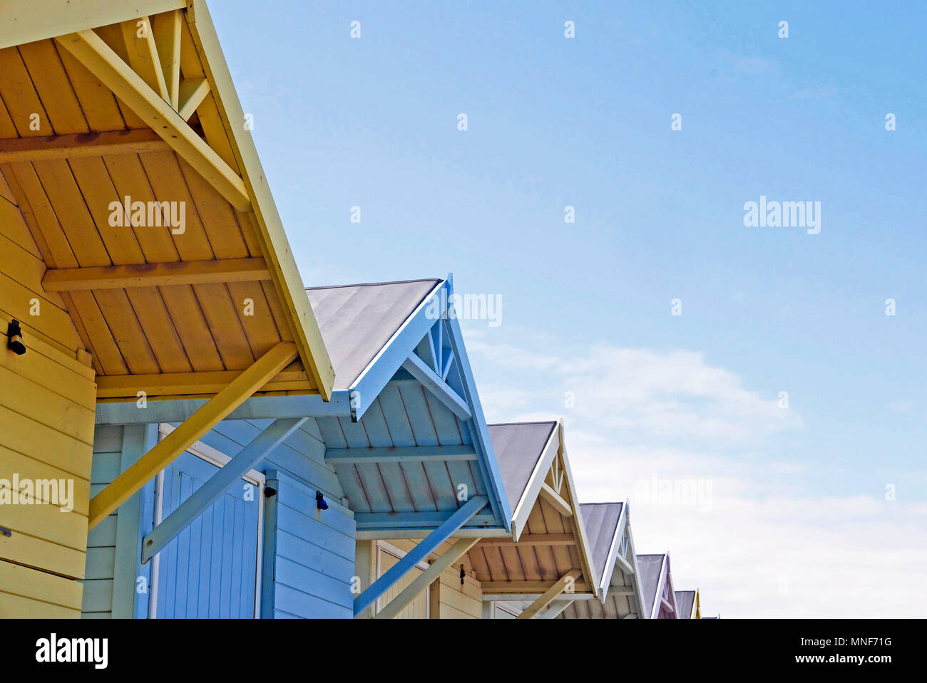 Apice di tetti di riga della pittoresca spiaggia di capanne contro il cielo blu Foto Stock