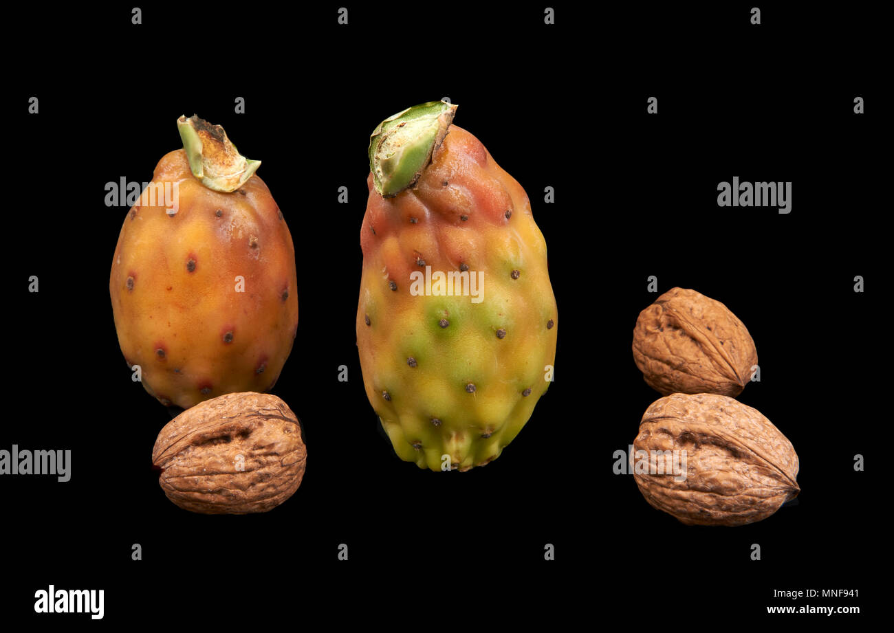 Alcuni fichidindia e alcune noci su sfondo nero Foto Stock