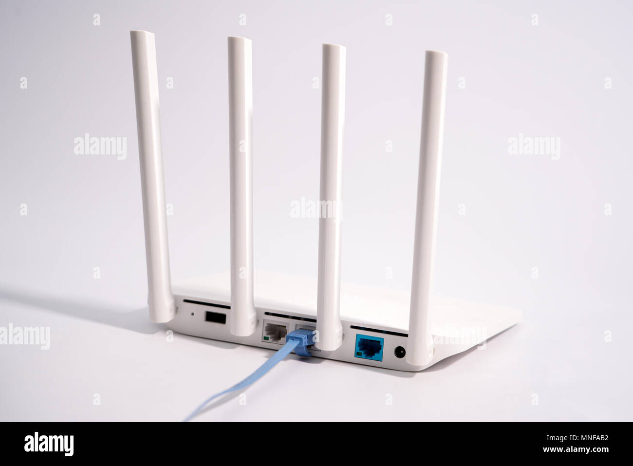 La vista posteriore del router che mostra la lan internet la porta e il cavo di terra è collegato a un router di bianco Foto Stock