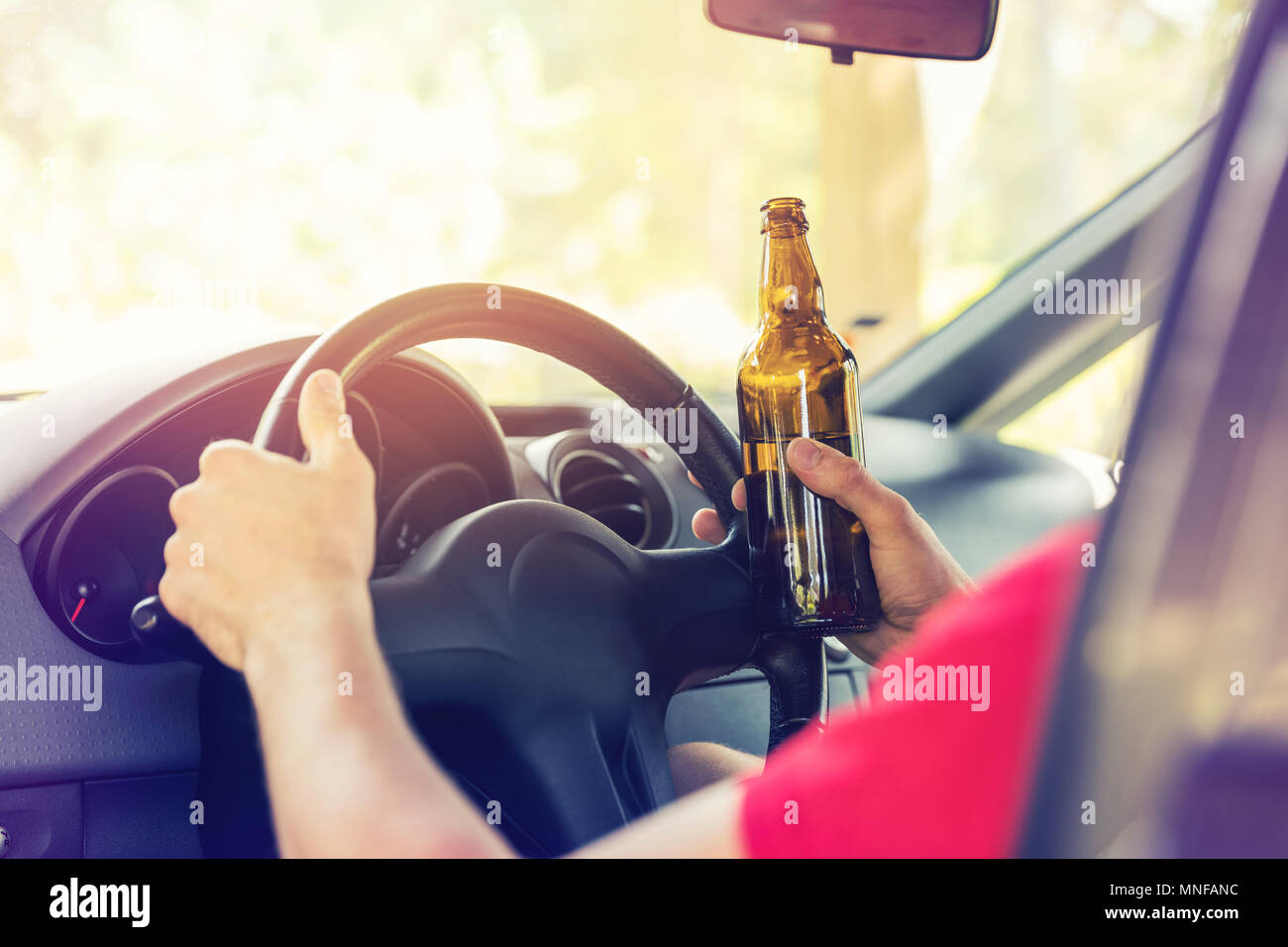 Bere birra mentre si è alla guida di un veicolo Foto Stock