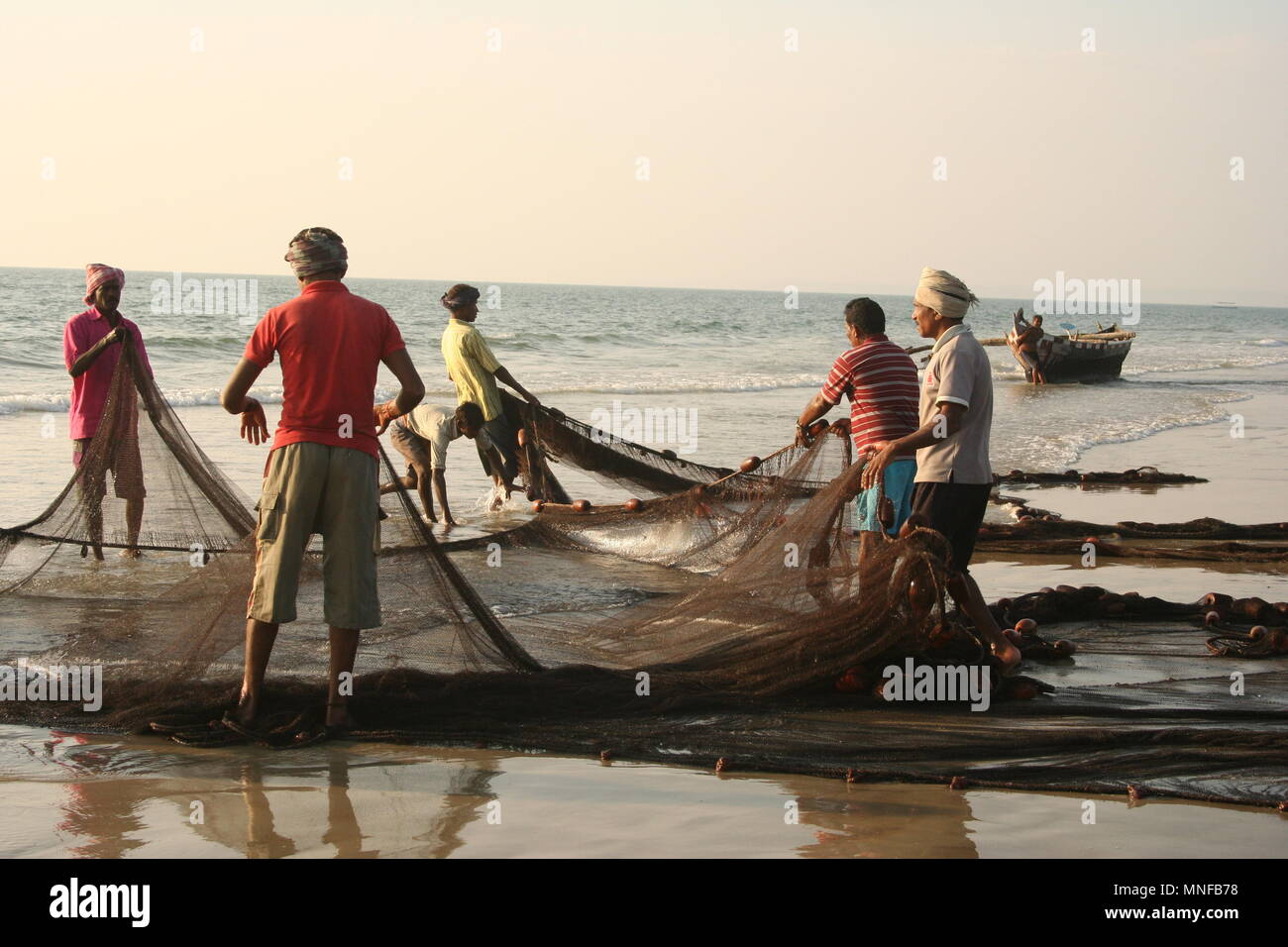 I Pescatori indiani con Net sulla spiaggia, Colva, India Foto Stock