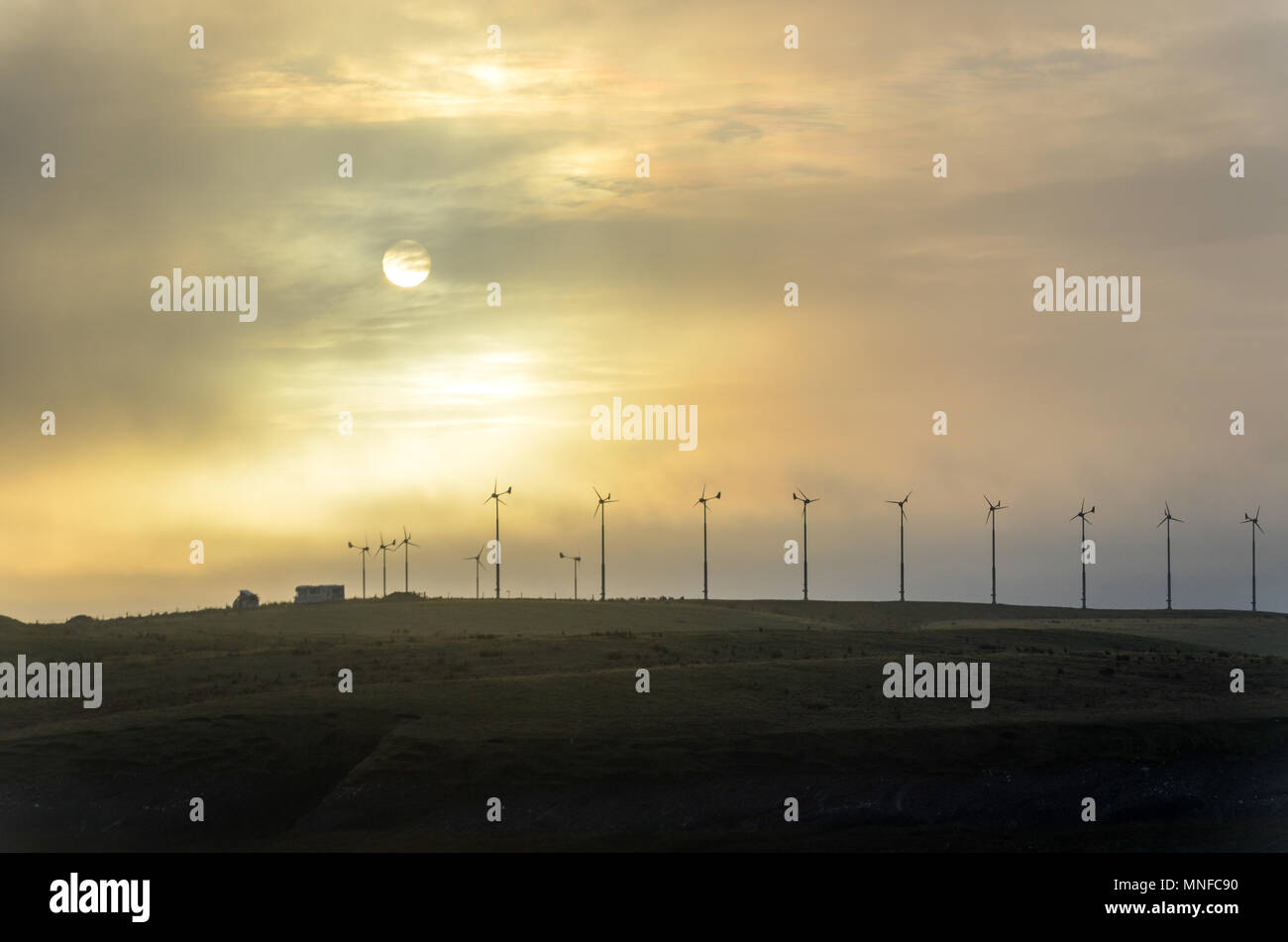 Sunrise e delle turbine a vento sulla rotta Stornoway, Ebridi Esterne, Scotland, Regno Unito Foto Stock