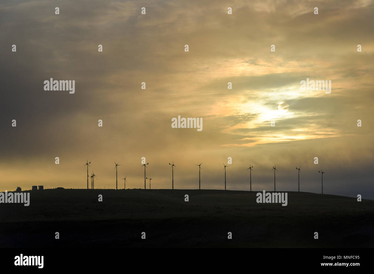 Sunrise e delle turbine a vento sulla rotta Stornoway, Ebridi Esterne, Scotland, Regno Unito Foto Stock