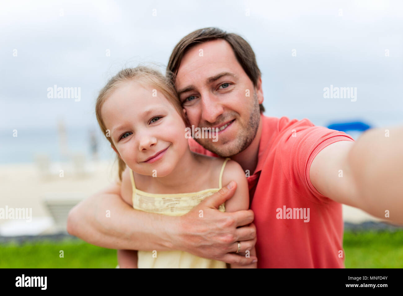 La famiglia felice padre e sua adorabile figlia piccola a beach tenendo selfie Foto Stock