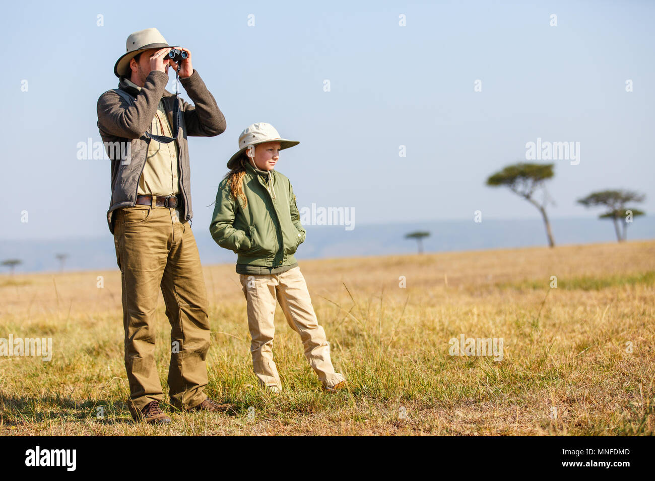 La famiglia del padre e figlio su safari Africano vacanze godendo di vista bush Foto Stock