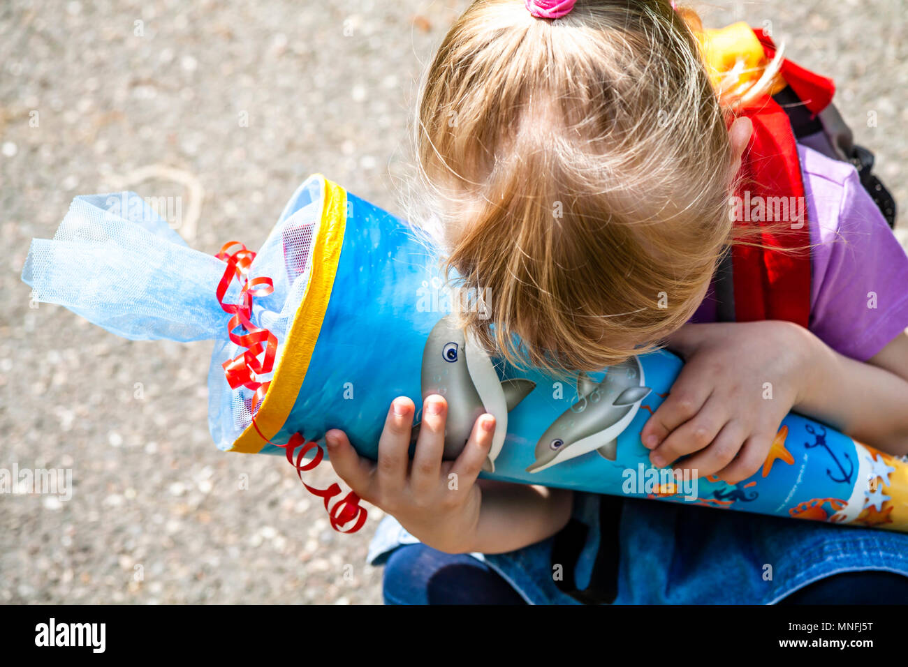 Bambina è felice con il suo cono di caramella sul suo primo giorno di scuola. Foto Stock