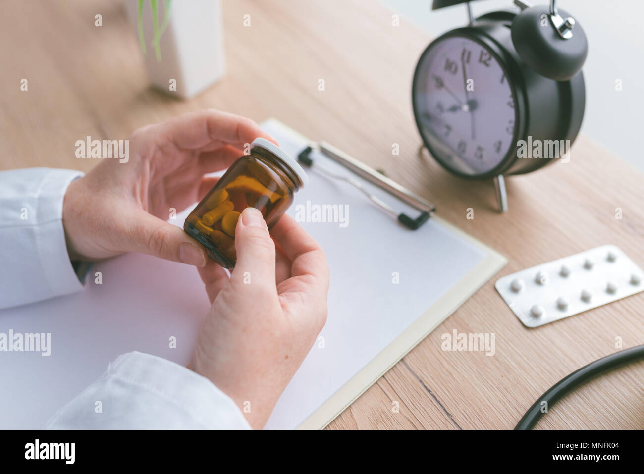 Medico donna tenendo la bottiglia non marcato di varie pillole e medicinali, farmaci generici concetto, la prescrizione medicina e sanità Foto Stock