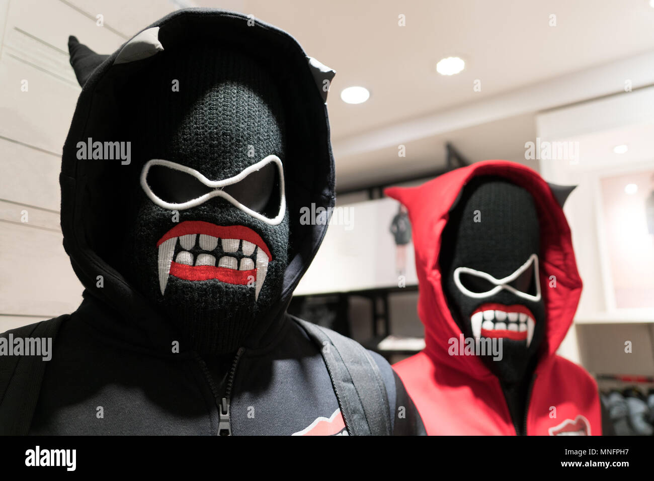 Una maschera di demoni, un paio di giacca a vento in bianco e nero e costume rosso sulla maschera del diavolo Foto Stock