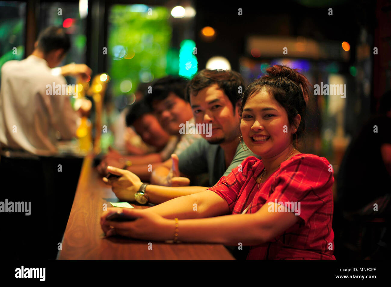Amici in attesa presso il bar per le loro birre, il luppolo Brew House Pattaya Thailandia Foto Stock