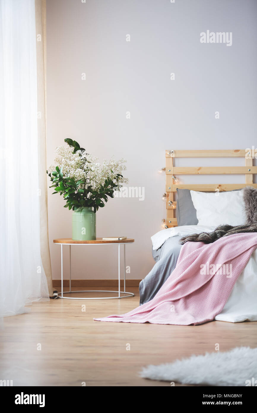 Letto moderno e piccolo comodino con mazzo di fiori in camera da letto Foto  stock - Alamy