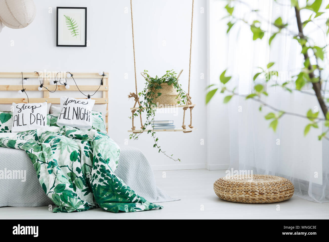 Camera da letto bianca con il rattan pouf, swing e letto matrimoniale Foto Stock