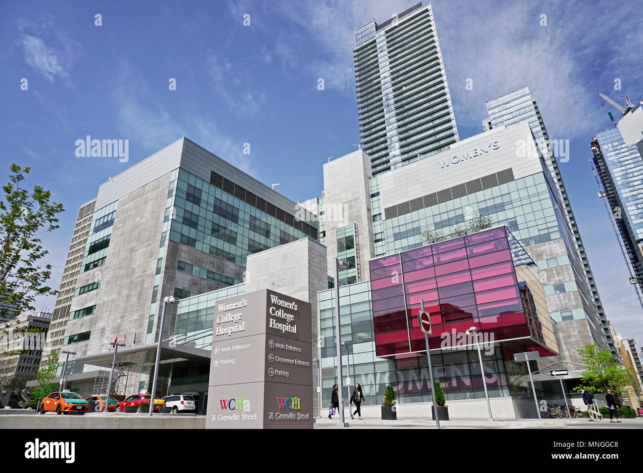 Facciata moderna femminile del College Hospital di Toronto su una soleggiata giornata di primavera con il cielo blu e nuvole bianche Foto Stock