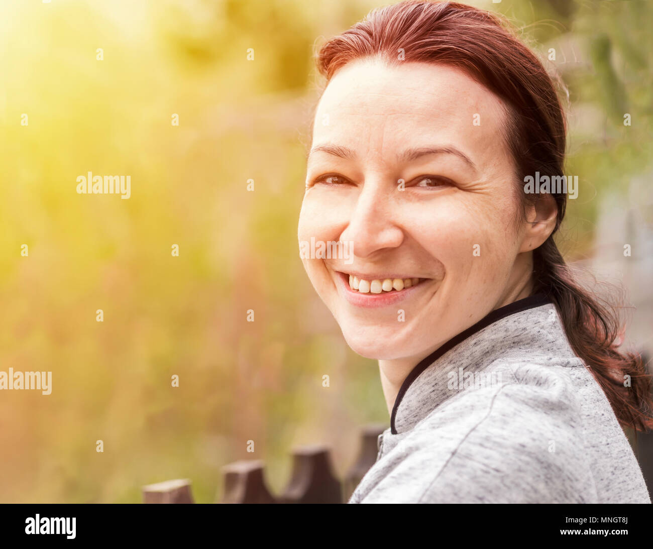 Felice giovane donna con pelle naturale in natura. Ritratto di donna con pelle naturale, nessun trucco, guardando la telecamera Foto Stock