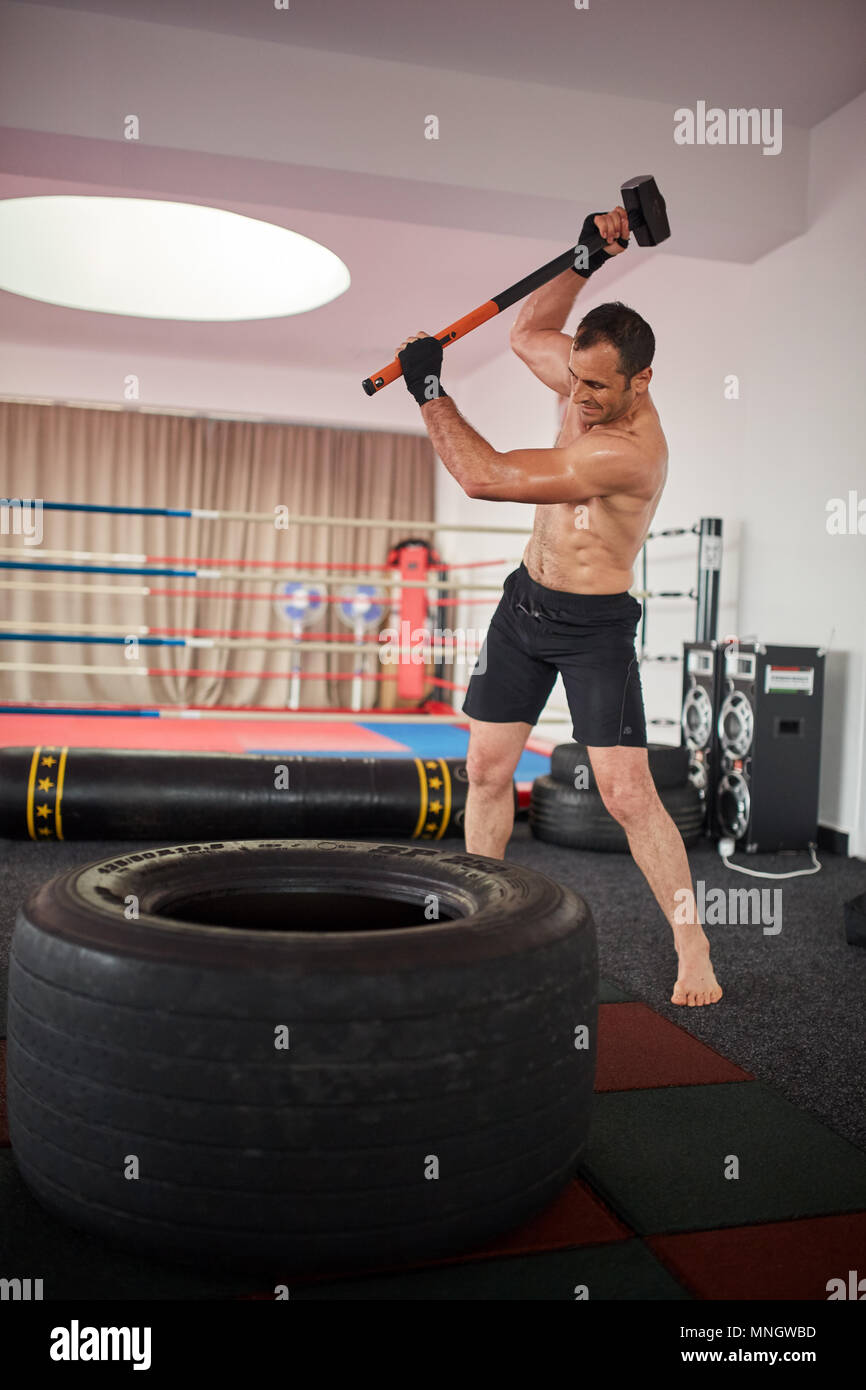Boxer in formazione con un martello e un grosso pneumatico Foto Stock