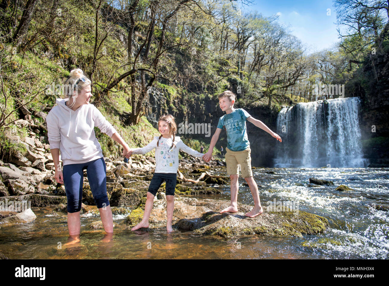 Quattro le cascate a piedi vicino Pontneddfechan in Brecon Beacons - una famiglia pale a la Sgwd yr Eira falls (cadute di neve) sul Fiume Hepste Foto Stock