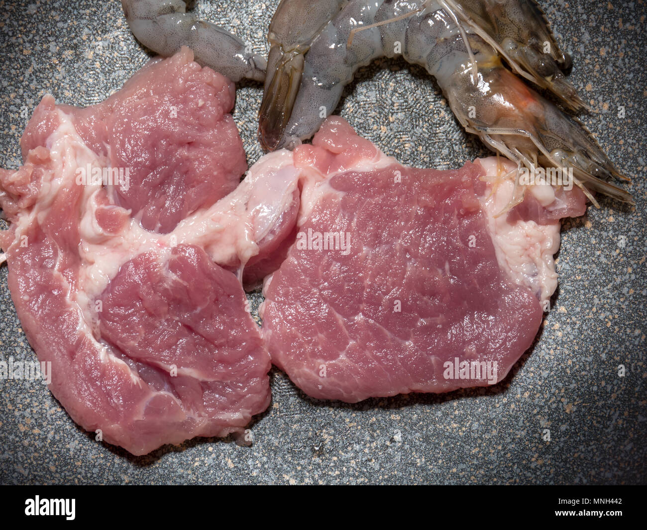 Carne di manzo crudo e gamberetti in pot nero Foto Stock