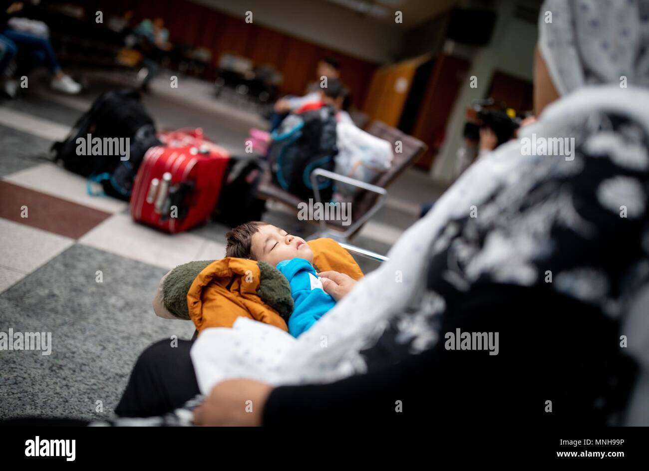 17 maggio 2018, Germania Berlino: il giovane figlio di una famiglia di profughi dall'Afghanistan dorme nella area di attesa al Landesamt fuer Fluechtlingsangelegenheiten (lit. agenzia di Stato per questioni dei rifugiati). Foto: Kay Nietfeld/dpa Foto Stock