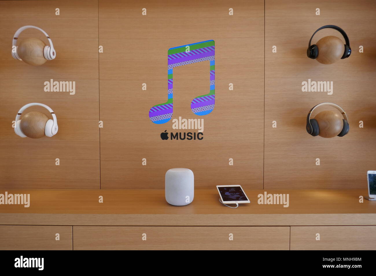 07 maggio 2018, STATI UNITI D'AMERICA, Cupertino: il logo del servizio di streaming musicale Apple Music, circondato da cuffie Beats e un altoparlante Homepod, raffigurato in Apple Store presso la nuova sede aziendale Apple Park. - Nessun filo SERVICE - foto: Christoph Dernbach/dpa Foto Stock