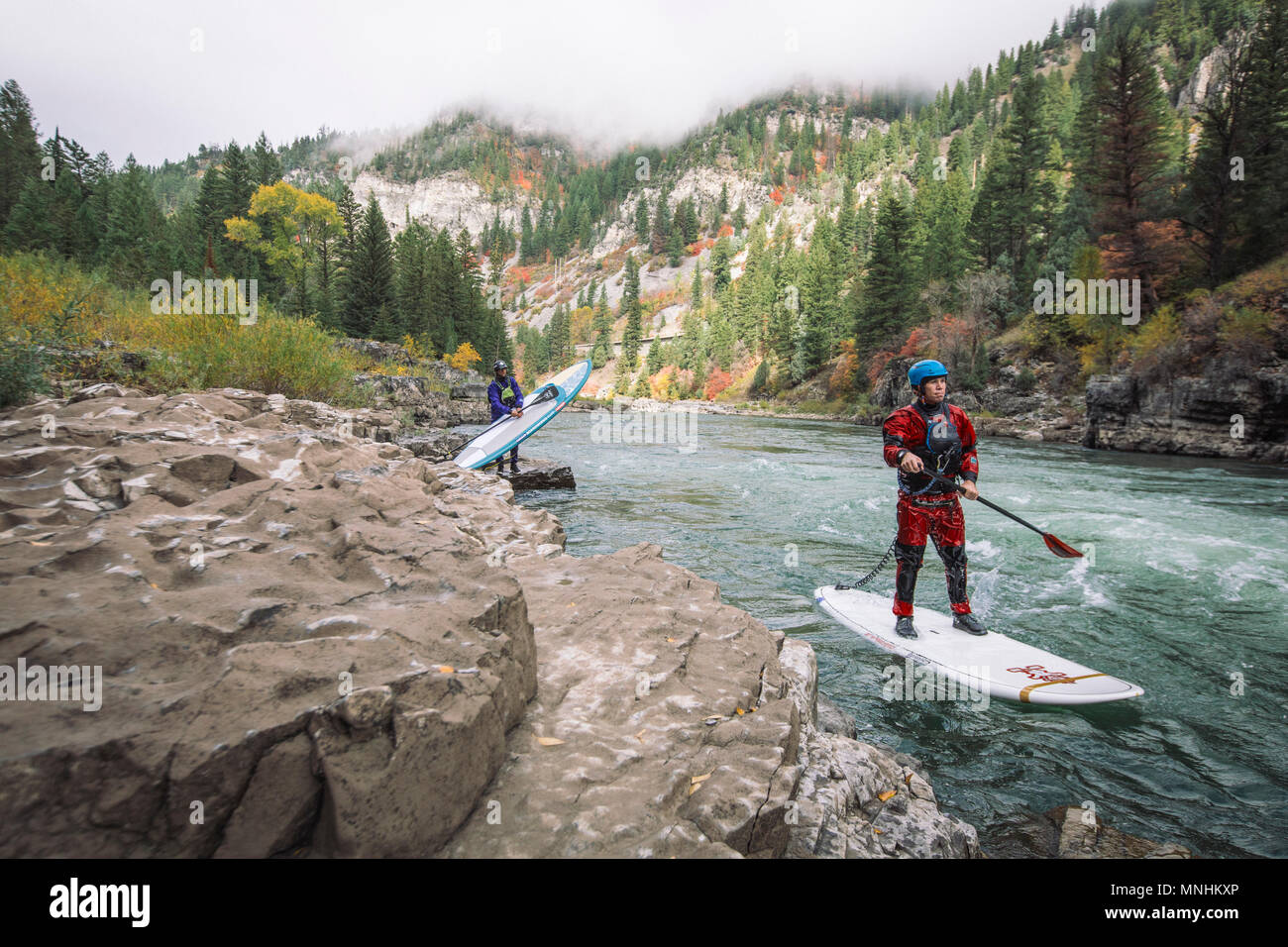 Due uomini avventurosi paddleboarding nel fiume Snake, Jackson, Wyoming USA Foto Stock