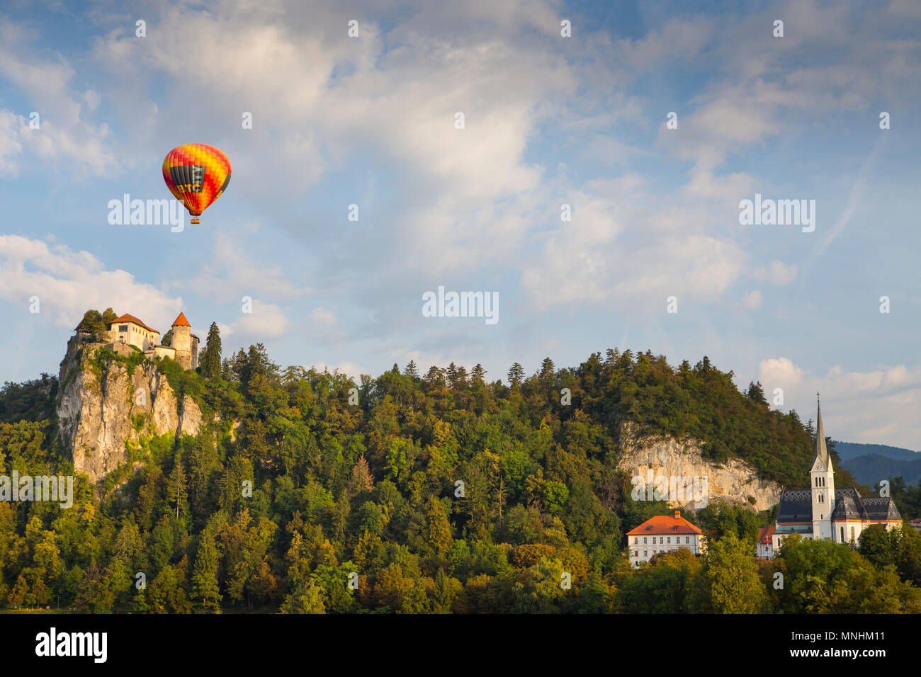 Mongolfiera Volare sotto il cielo blu con nuvole sopra il castello di Bled e foresta, Bled, Alta Carniola, Slovenia Foto Stock