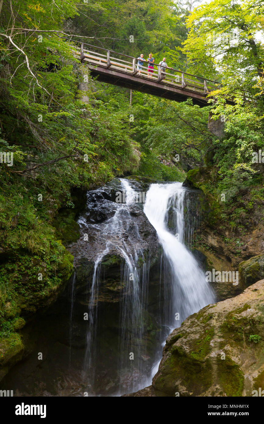 Tourist in piedi su un ponte di fronte alla famosa cascata di Somma in gola gorge, Slovenia. La gola gorge è un burrone nelle immediate vicinanze Foto Stock