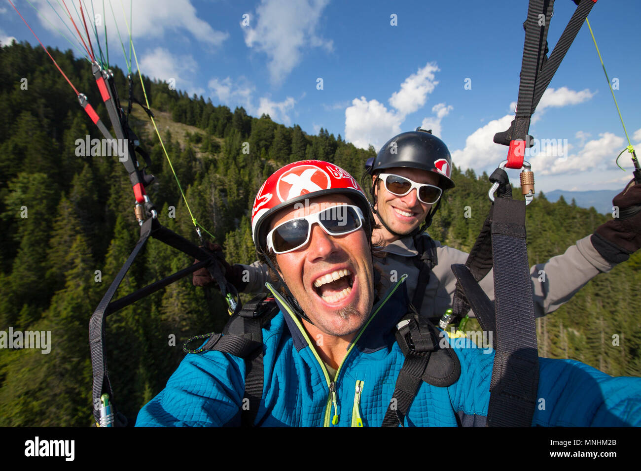 Due lieti parapendii stanno prendendo un selfie mentre in alto in aria dopo il decollo dall'Dobrca montagna vicino a Begunje e Radovljica Slovenia Foto Stock