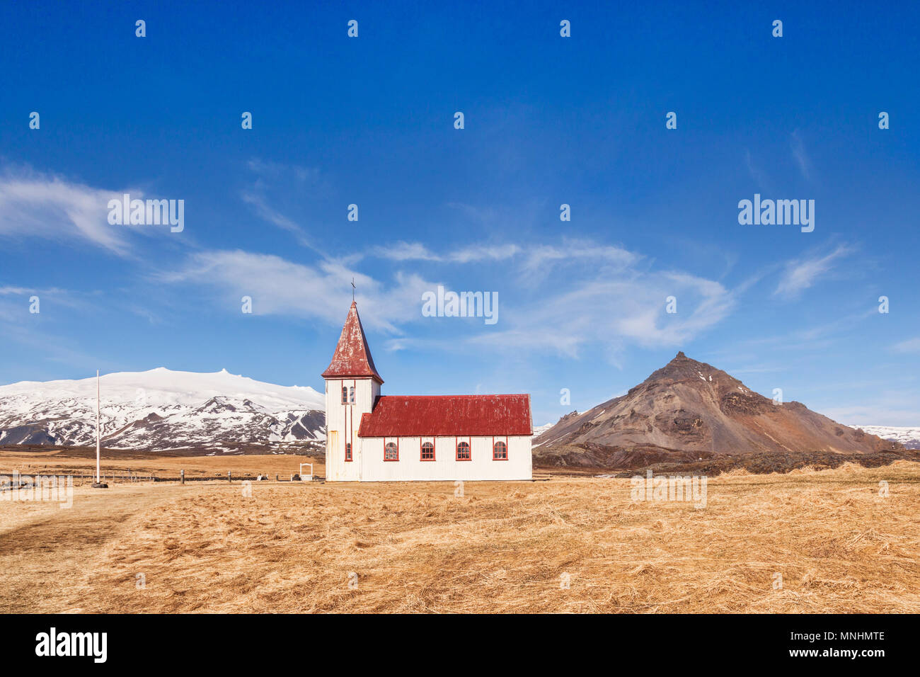 Bianco chiesa di legno a Hellnar, Snaefellsnes Peninsula, West Islanda. Sulla sinistra è il vulcano Snaefellsjokull, ricoperta di neve e sulla destra è Foto Stock