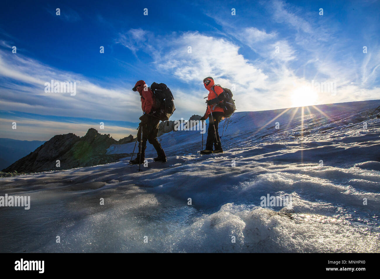 Due alpinisti ghiacciaio in discesa su pendii del monte Shuksan al tramonto, nello Stato di Washington, USA Foto Stock