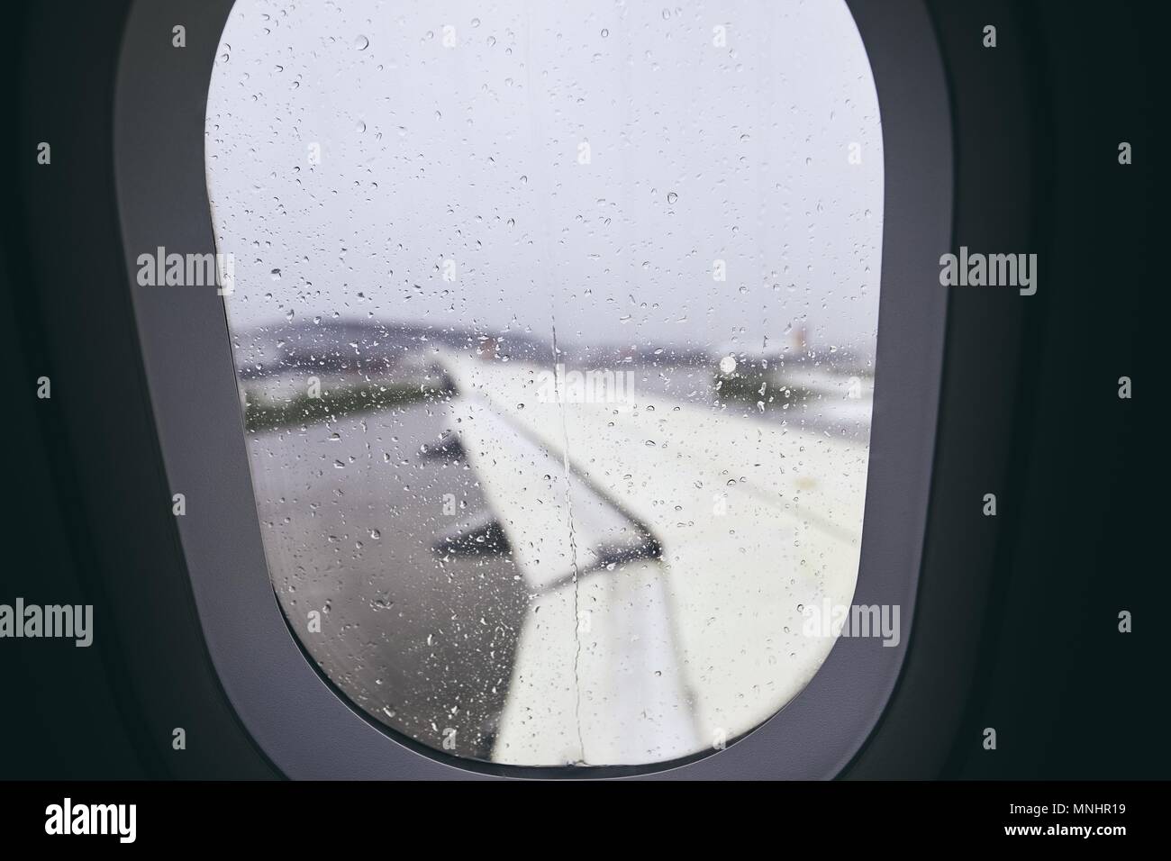 Close-up della finestra aereo durante la pioggia. Messa a fuoco selettiva su gocce di pioggia. Foto Stock