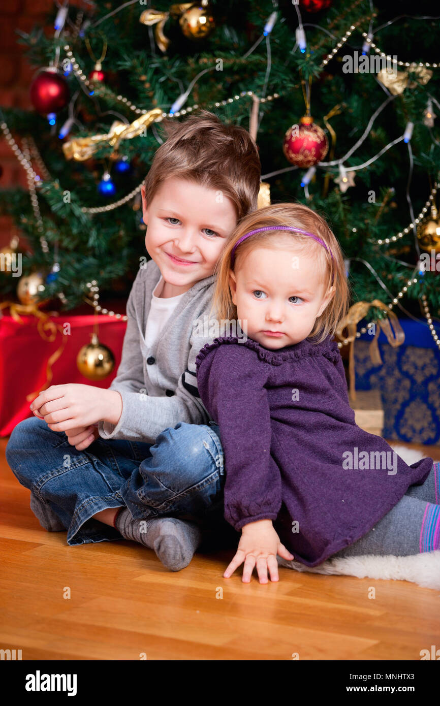 2 Bambini Piccoli Seduti Vicino Al Bellissimo Albero Di Natale Foto Stock Alamy