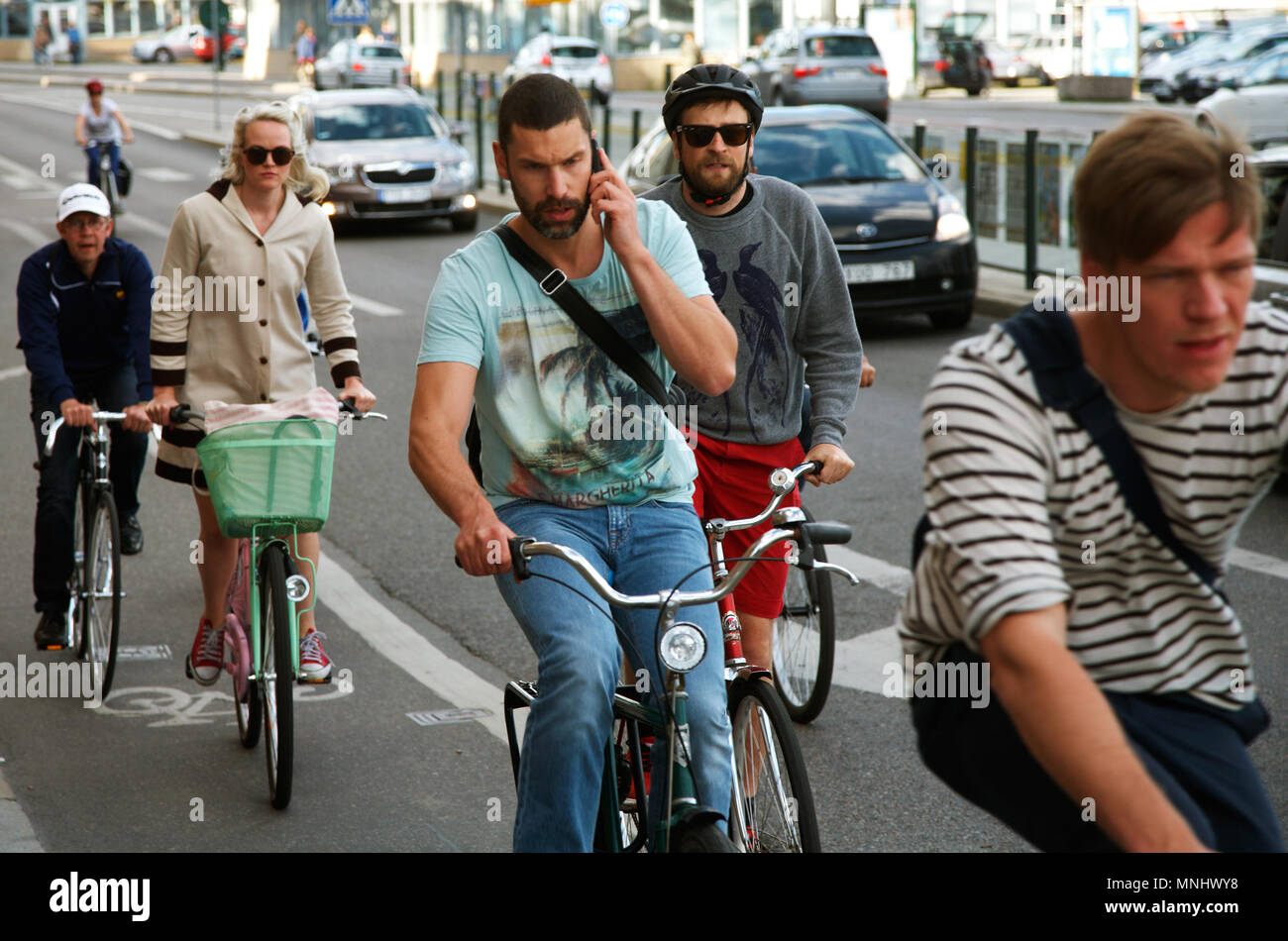 Stoccolma, Svezia - 20 Giugno 2012: Un ciclista maschio senza un casco, parlare su un telefono mobile tra i ciclisti nel traffico su tSkeppsbron in Stockho Foto Stock
