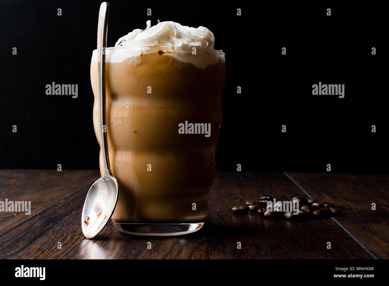 Caffè freddo con panna e latte, il cucchiaio e i chicchi di caffè bevanda concetto. Foto Stock