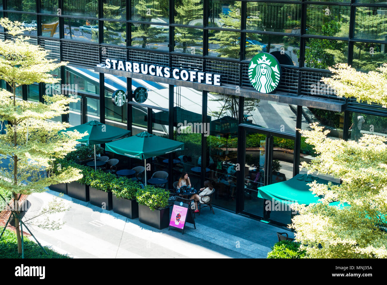 Rilassante giornata soleggiata presso Starbucks Cina, due cinesi Foto Stock
