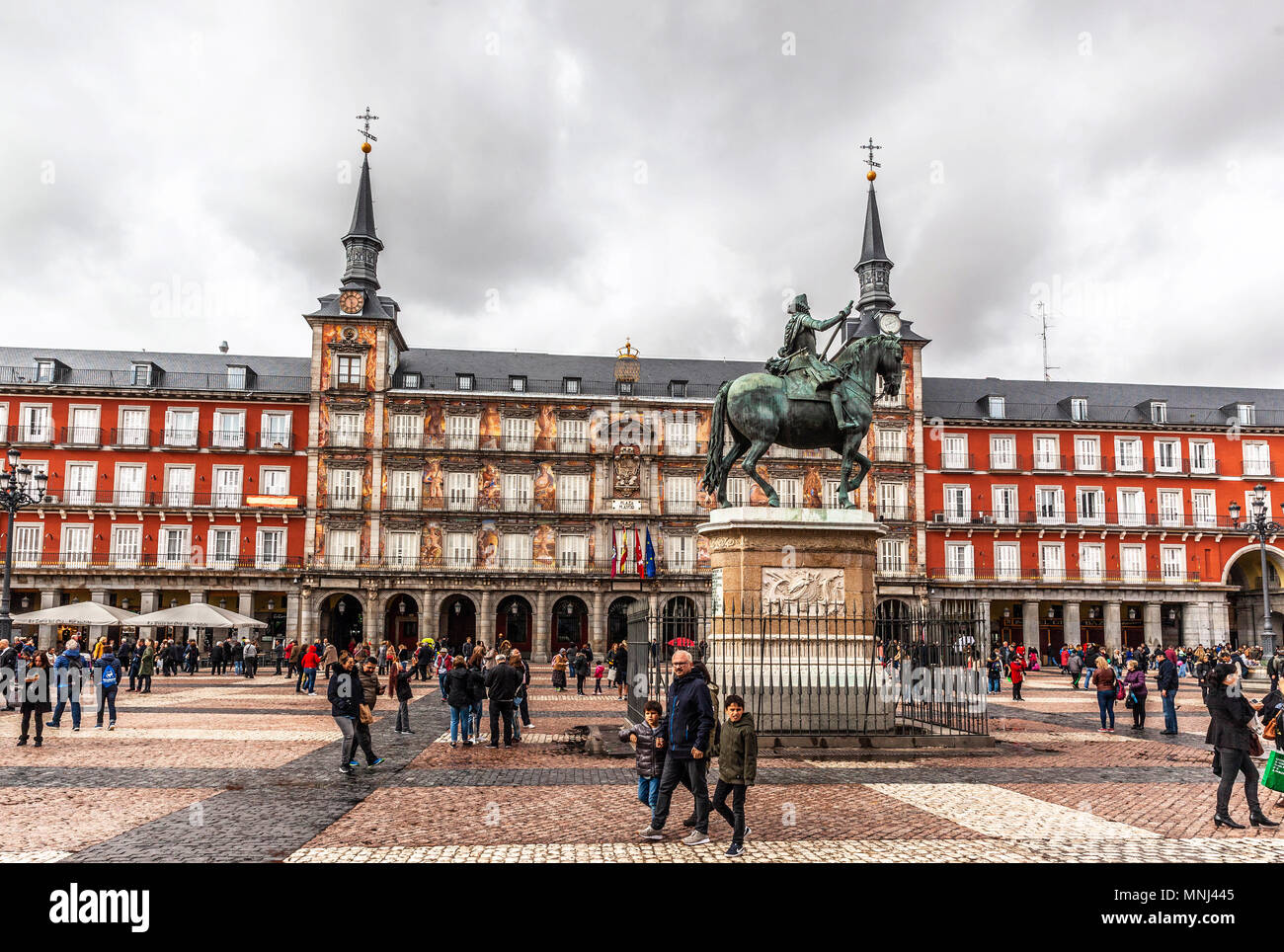 I visitatori passeggiano intorno alla statua equestre di Re Filippo III in Plaza Mayor, Madrid, Spagna. Foto Stock