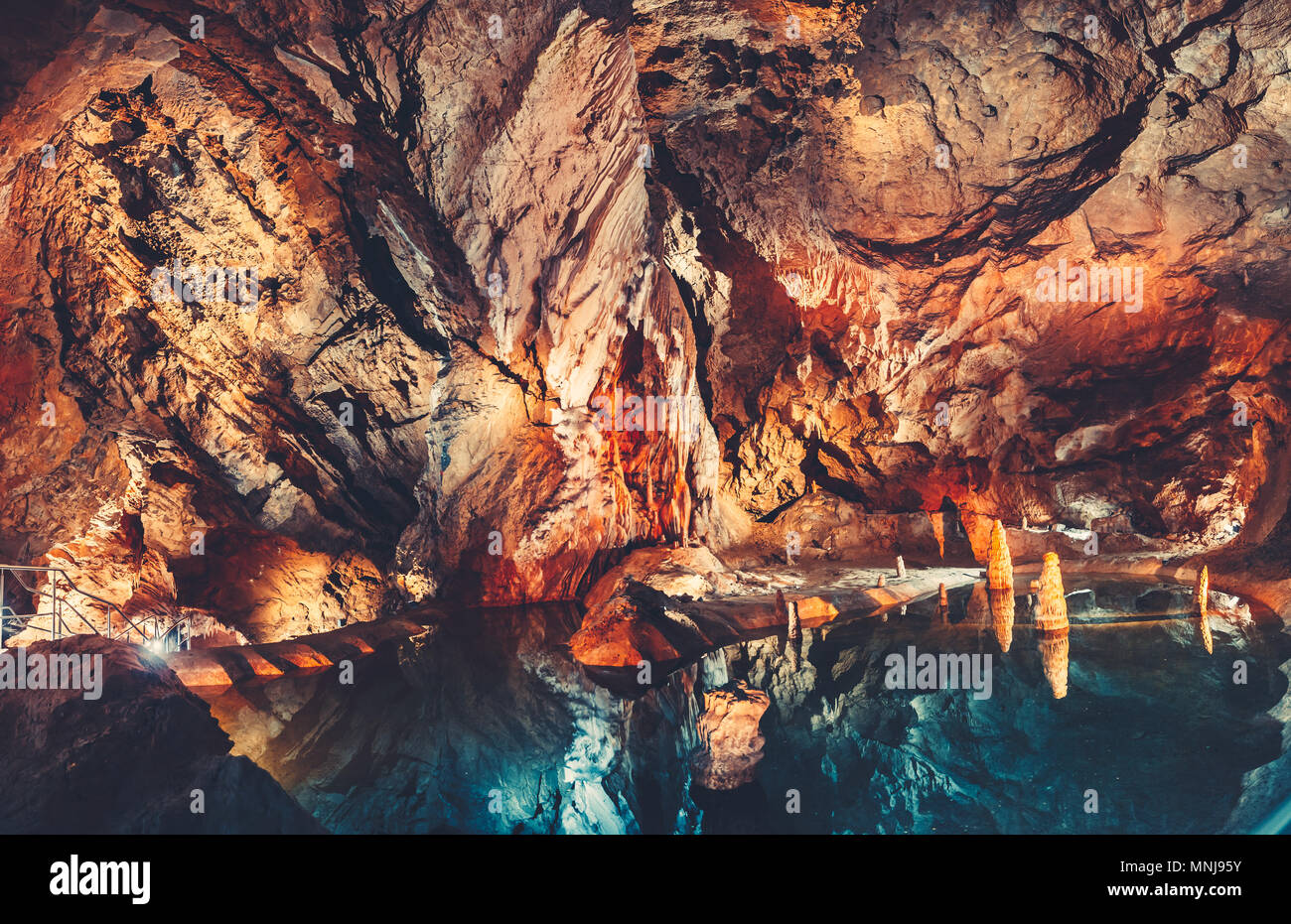 Splendida vista interna della grotta nella grotta con le acque cristalline del lago. Fiaba golden arancione e blu scuro la combinazione dei colori. La Tatra M Foto Stock