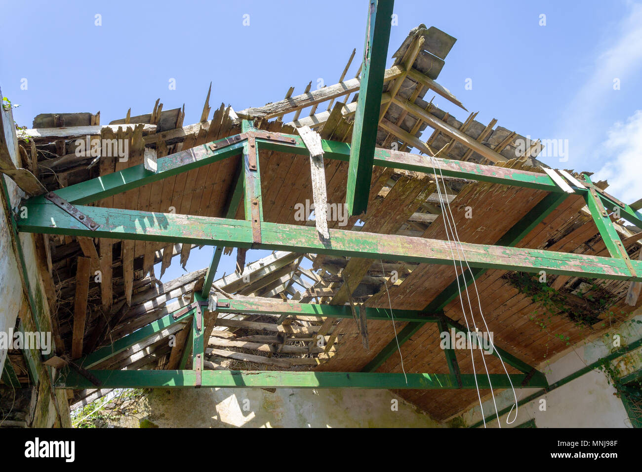 Abbandonata e crolli di scuola di villaggio casa tetto di legno lentamente decadere aperta alle intemperie. Foto Stock
