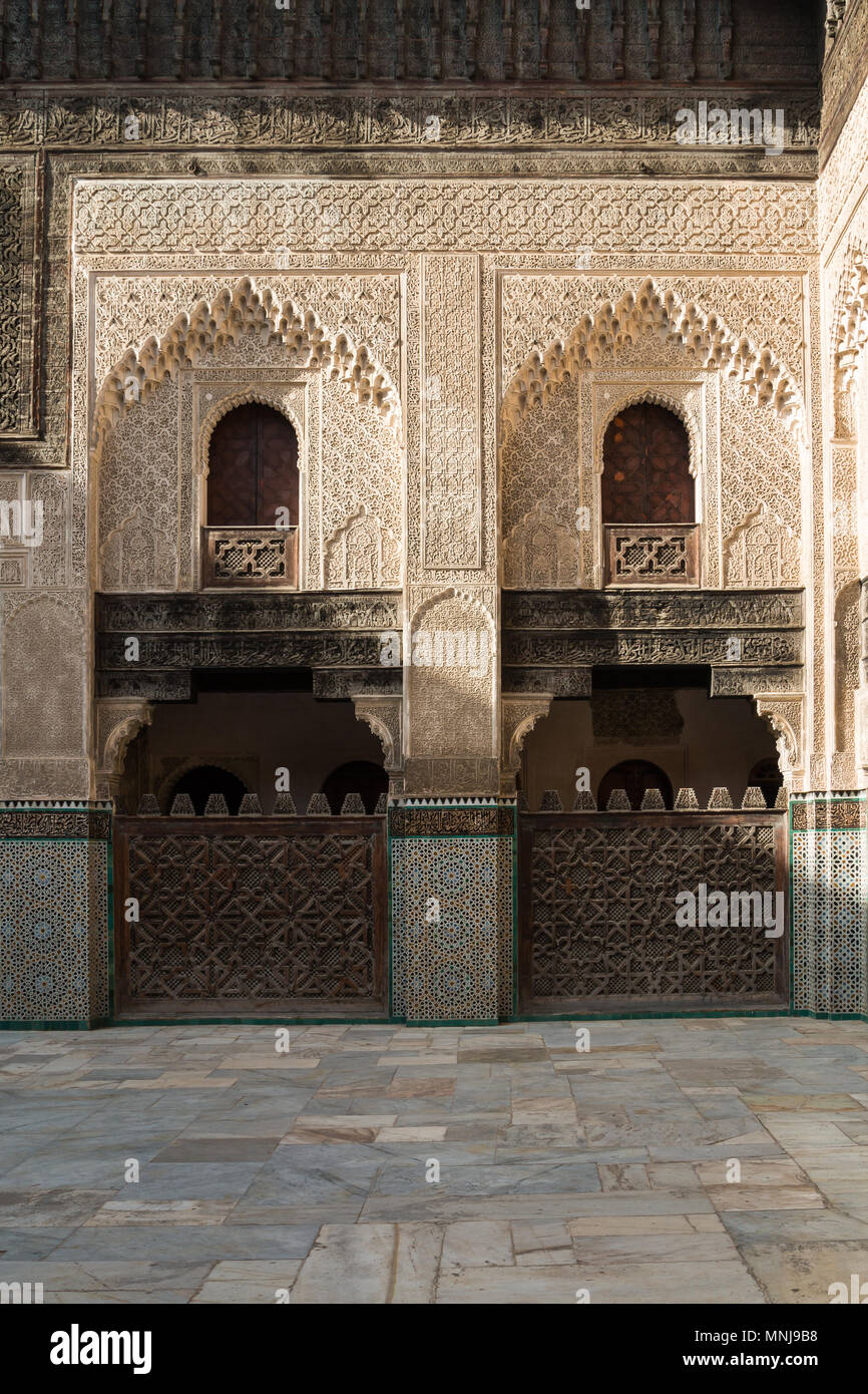 Ornano le pareti in pietra con dettagli tradizionali. Scuola Islamica Madrasa Bou Inania a Fez, in Marocco. Foto Stock