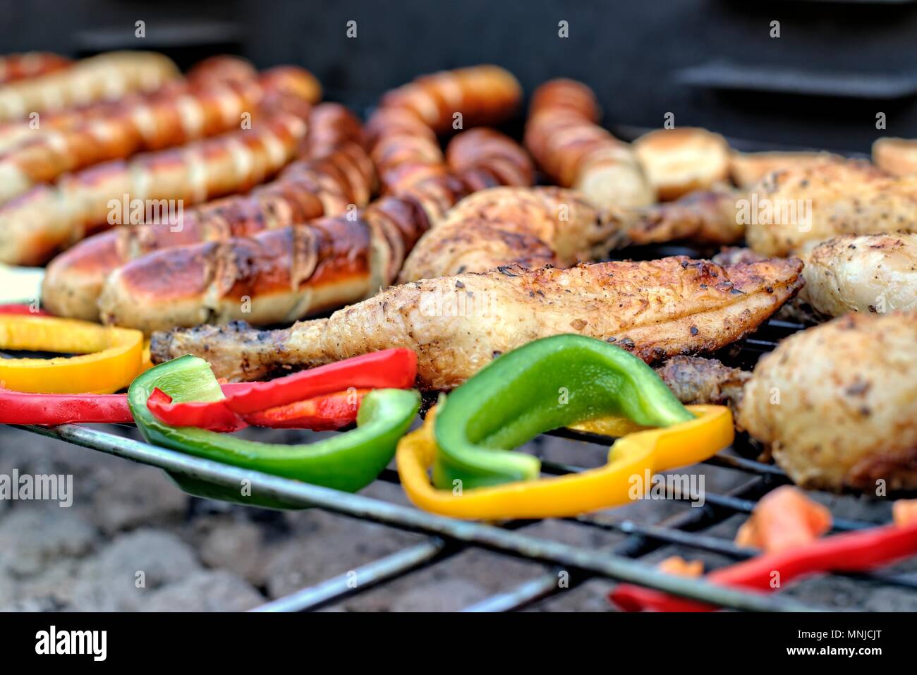 Il cibo era gustoso, nutrizione, della cucina e del barbecue concetto: salsicce alla griglia,coscia di pollo e verdure su un barbeque. Foto Stock